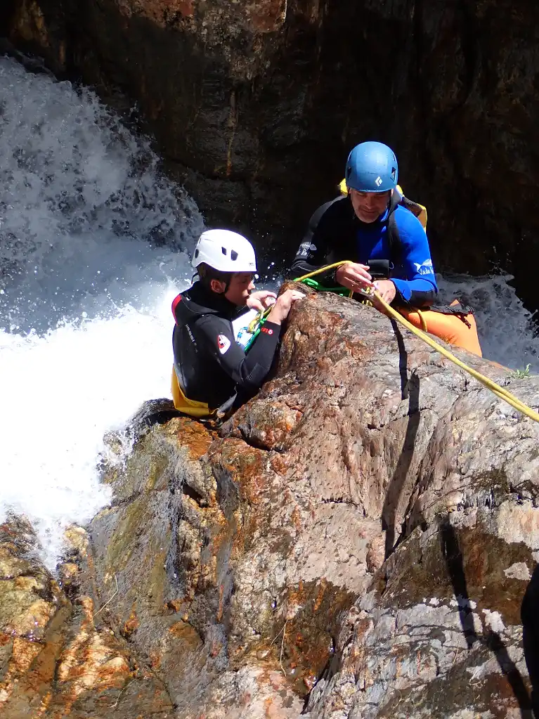 Canyon de l’Artigue : un toboggan sensationnel pour les amateurs de canyoning en Ariège Canyoneur prêt à glisser dans le toboggan du canyon de l’Artigue, Ariège